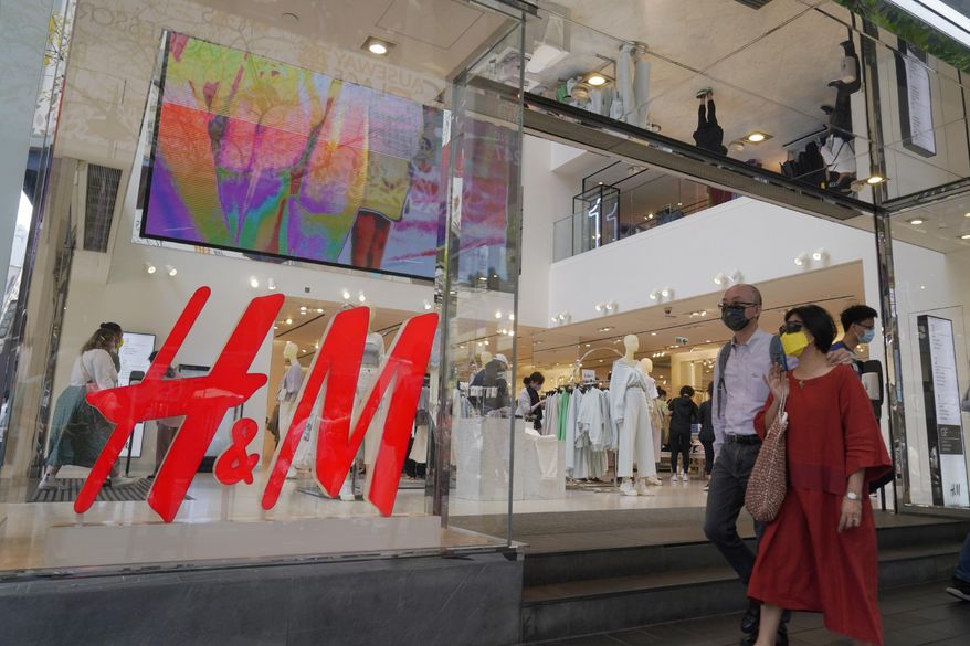 People walk past an H&amp;amp;M clothing store in Hong Kong, Saturday, March 27, 2021. H&amp;amp;M disappeared from the internet in China as the government raised pressure on shoe and clothing brands and announced sanctions Friday, March 26, 2021, against British officials in a spiraling fight over complaints of abuses in the Xinjiang region. (AP Photo/Kin Cheung)