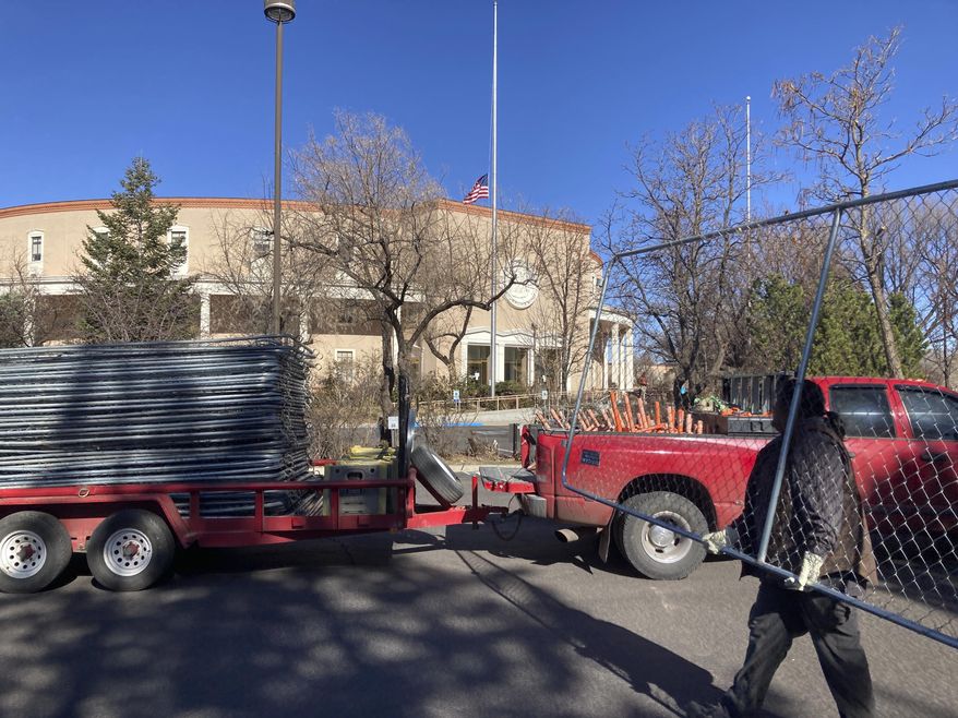 Workers remove segments of the chain-link fence around the New Mexico state capitol in Santa Fe on Saturday, March 27, 2021. The fence was erected by National Guardsman and State Police officers following Jan. 6, 2021, riots in Washington, D.C. The added security cost at least $700,000 with over $15,000 going for the fence rental, according to a March 12, 2021, response from state officials that did not include the cost of removing it. (AP Photo/Cedar Attanasio)