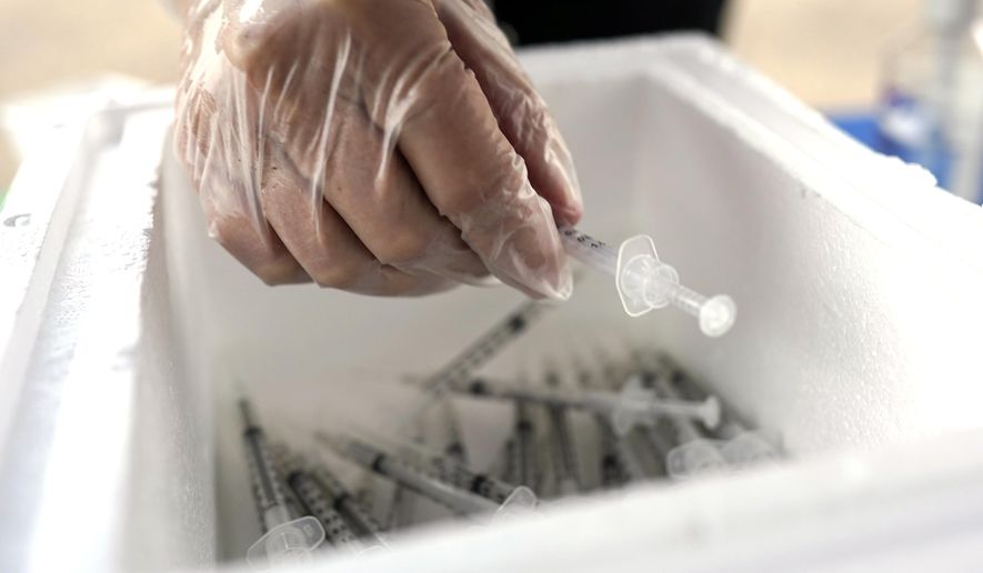 Spring Branch Independent School District nurse Tricia Anderson removes a Pfizer COVID-19 vaccination shot from a cooler during a vaccination drive for education workers Tuesday, March 16, 2021, in Houston. (AP Photo/David J. Phillip)