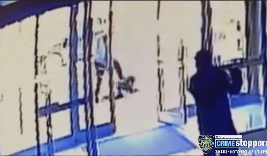 This image taken from surveillance video provided by the New York City Police Department shows a person of interest, background center, assaulting an Asian American woman, on ground, Monday, March 29, 2021, in New York. The 65-year-old woman was walking in midtown Manhattan a few blocks from Times Square on Monday afternoon when a man approached her and kicked her in the stomach, knocking her to the ground, police said. (Courtesy of New York Police Department via AP)
