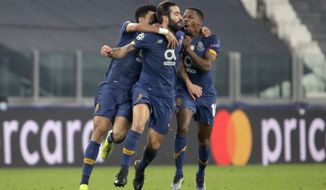 Porto&#39;s Sergio Oliveira, center, celebrates after scoring his side&#39;s second goal during the Champions League, round of 16, second leg, soccer match between Juventus and Porto in Turin, Italy, Tuesday, March 9, 2021. (AP Photo/Luca Bruno)