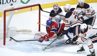 Montreal Canadiens&#39; Brendan Gallagher (11) dives for a lose puck to score past Edmonton Oilers goaltender Mikko Koskinen during the first period of an NHL hockey game, Tuesday, March 30, 2021 in Montreal. (Paul Chiasson/The Canadian Press via AP)