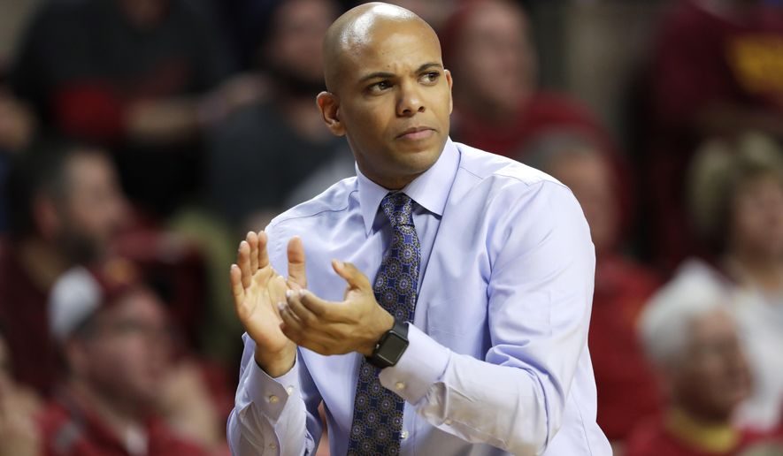 FILE - In this Monday, Nov. 14, 2016 file photo, Then-Mount St. Mary&#x27;s head coach Jamion Christian applauds his team during the first half of an NCAA college basketball game against Iowa State in Ames, Iowa. For all the stops and starts endured by men&#x27;s and women&#x27;s college basketball teams because of the pandemic, more than 80% of scheduled conference games were played this season, according to research by The Associated Press. The season was nonetheless a grind for most teams and none had it harder than the George Washington men and UC Davis women.  (AP Photo/Charlie Neibergall, File)