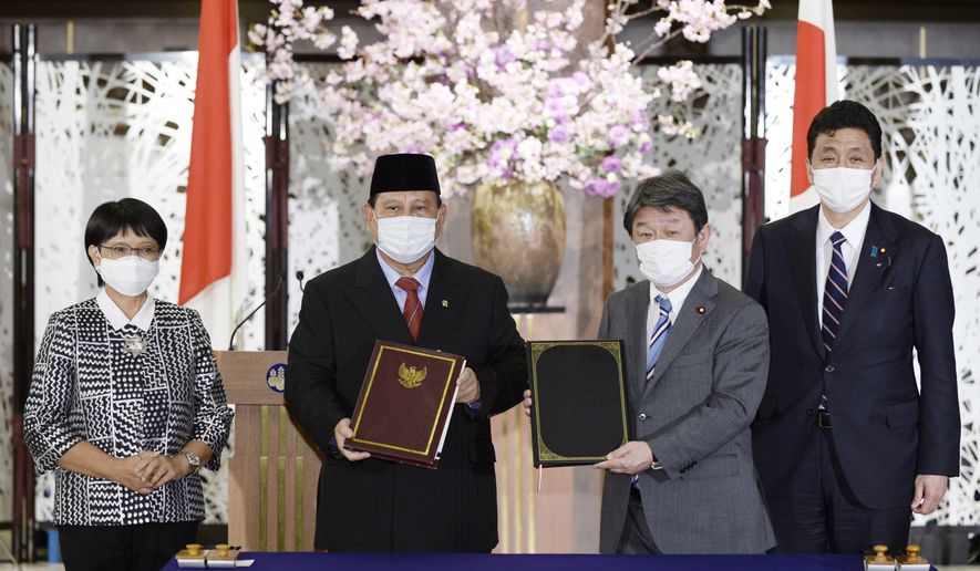 Indonesian Foreign Minister Retno Marsudi, from left, Defense Minister Prabowo Subianto, Japanese Foreign Minister Toshimitsu Motegi and Defense Minister Kishi Nobuo pose for a photo during a signing ceremony for their foreign and defense ministers' meetings in Tokyo on Tuesday, March 30, 2021. (David Mareuil/Pool Photo via AP)