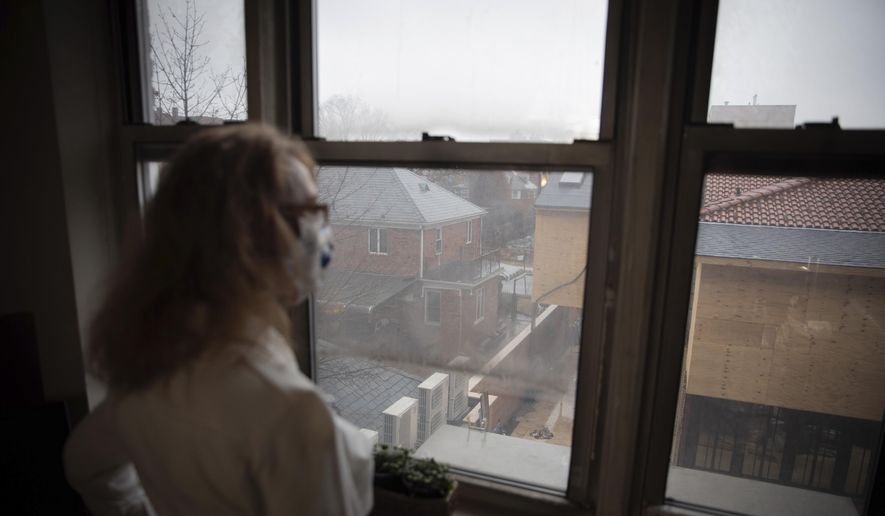 Bonney Ginett gazes out the window of her apartment in the Queens borough of New York on Thursday, March 18, 2021. Ginett, whose massage therapy business dried up during the pandemic, applied for help in July and said she was denied in October because she failed to prove loss of income. The 65-year-old New York City resident now owes more than $26,000 in back rent on her one-bedroom apartment and fears eviction. (AP Photo/Robert Bumsted) ** FILE **