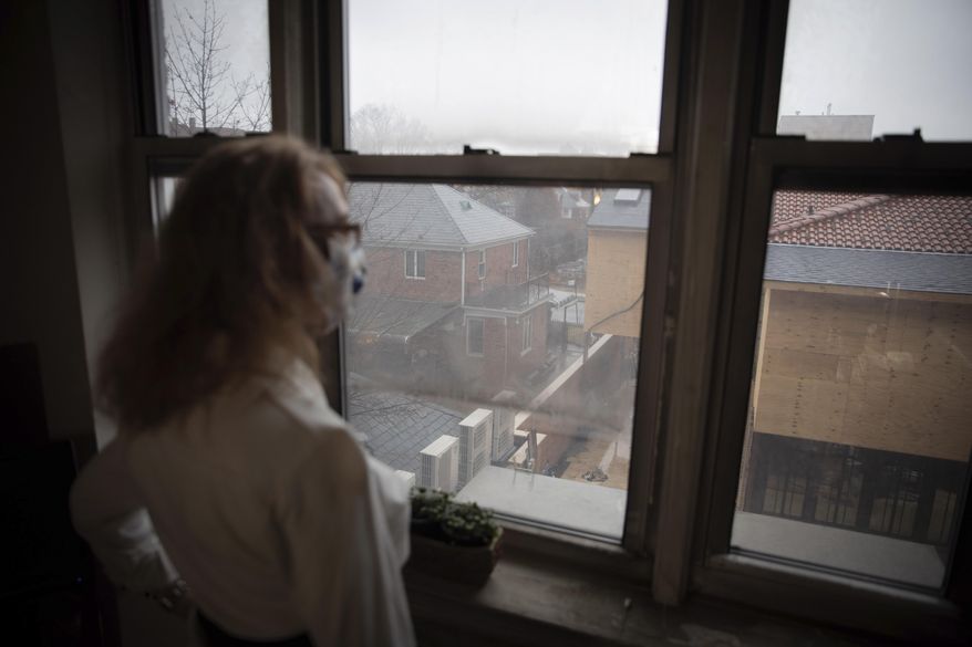 Bonney Ginett gazes out the window of her apartment in the Queens borough of New York on Thursday, March 18, 2021. Ginett, whose massage therapy business dried up during the pandemic, applied for help in July and said she was denied in October because she failed to prove loss of income. The 65-year-old New York City resident now owes more than $26,000 in back rent on her one-bedroom apartment and fears eviction. (AP Photo/Robert Bumsted) ** FILE **