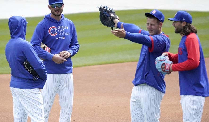 Chicago Cubs third baseman Kris Bryant, second from left, talks to Ian Happ, left, as first baseman Anthony Rizzo shows center fielder Jake Marisnick Wrigley Field during the team&#39;s last baseball workout Wednesday, March 31, 2021, before opening day Thursday, April 1, 2021, against the Pittsburgh Pirates in Chicago. (AP Photo/Charles Rex Arbogast)