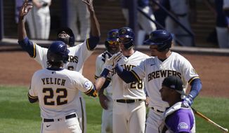 Milwaukee Brewers&#x27; Christian Yelich (22) celebrates with teammates after hitting a grand slam during the third inning of a spring training baseball game against the Colorado Rockies Wednesday, March 24, 2021, in Phoenix. Yelich, Daniel Robertson, Kolten Wong, and Lorenzo Cain scored. (AP Photo/Ashley Landis)