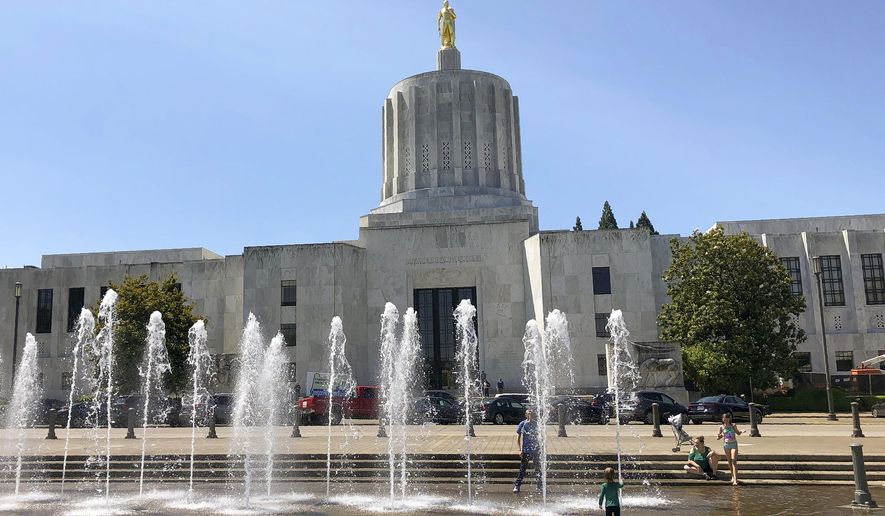 In this June 29, 2019, file photo, children play in fountains at the Oregon State Capitol in Salem, Ore. (AP Photo/Andrew Selsky, File)