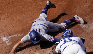 Texas Rangers&#39; Brock Holt (16) is tagged out by Kansas City Royals catcher Salvador Perez trying to score on a single by Jose Trevino during the first inning of a baseball game Thursday, April 1, 2021, in Kansas City, Mo. (AP Photo/Charlie Riedel)