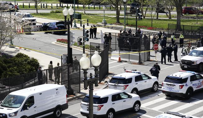 Police officers gather near a car that crashed into a barrier on Capitol Hill in Washington, Friday, April 2, 2021. (AP Photo/J. Scott Applewhite)