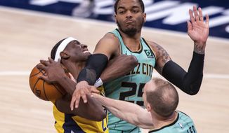Indiana Pacers guard Caris LeVert (22) is fouled by Charlotte Hornets forward P.J. Washington (25) while taking a shot during the second half of an NBA basketball game in Indianapolis, Friday, April 2, 2021. (AP Photo/Doug McSchooler)