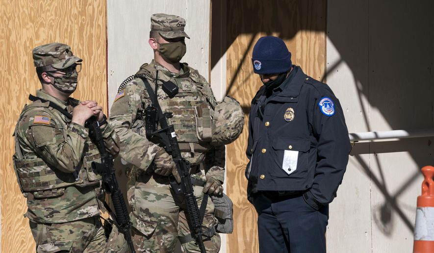 In this file photo, a U.S. Capitol Police officer, right, stands with two National Guard members near the scene where a fellow officer was killed after a man rammed a car into two officers at a barricade outside the U.S. Capitol and then emerged wielding a knife, on Capitol Hill in Washington, Friday, April 2, 2021. (AP Photo/J. Scott Applewhite)  **FILE**