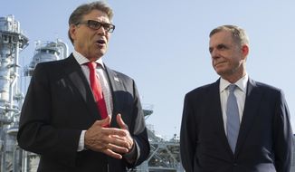 FILE - In this Thursday, July 26, 2018 file photo, Secretary of Energy Rick Perry, left, with the main cyrogenic heating exchange behind him, and Thomas Farrell, II, chairman, president and CEO, Dominion Energy, speak with reporters at Dominion Energy&#39;s Cove Point LNG liquefaction Project facility in Lusby, Md., Tom Farrell, who led Dominion Energy for more than a decade, has died Friday, April 2, 2021 one day after he stepped down from his post. He was 66. (AP Photo/Cliff Owen, File)