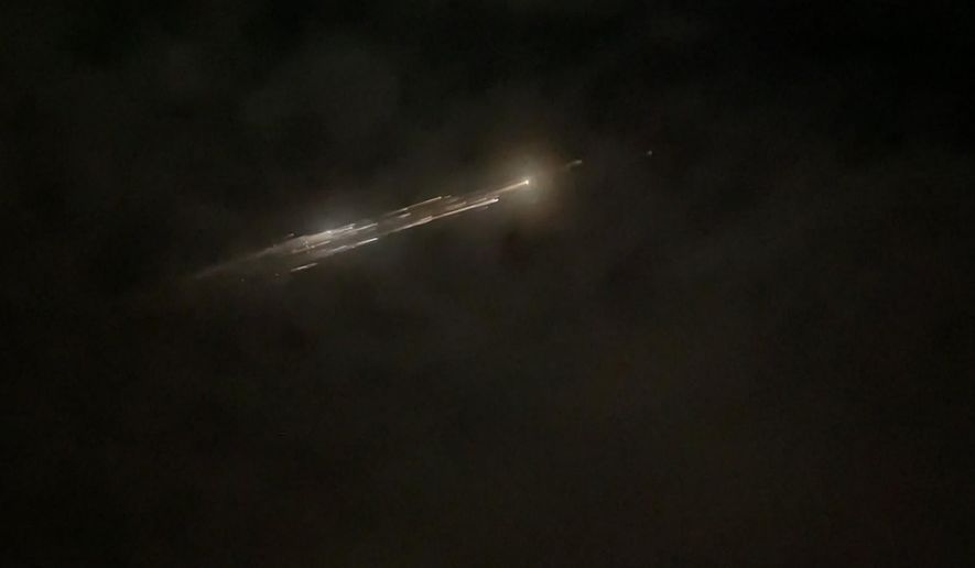 In this image taken from video provided by Roman Puzhlyakov, debris from a SpaceX rocket lights up the sky behind clouds over Vancouver, Wash. Thursday evening, March 25, 2021. The remnants of the second stage of the Falcon 9 rocket left comet-like trails as they burned up upon re-entry in the Earth&#39;s atmosphere according to a tweet from the National Weather Service. (Roman Puzhlyakov via AP)