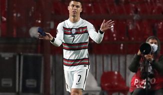 Portugal&#39;s Cristiano Ronaldo holding captain&#39;s armband, left, reacts during the World Cup 2022 group A qualifying soccer match against Serbia at the Rajko Mitic stadium in Belgrade, Serbia, Saturday, March 27, 2021. The captain’s armband which Cristiano Ronaldo threw to the pitch after his overtime winning goal was disallowed in a World Cup qualifier against Serbia has been put on auction Tuesday March 30, 2021.  The armband is being auctioned by a charity group raising money for surgery of a six-month-old boy from Serbia suffering spinal muscular atrophy. (AP Photo/Darko Vojinovic)