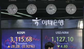 A currency trader walks near the screens showing the Korea Composite Stock Price Index (KOSPI), left, and the foreign exchange rate between U.S. dollar and South Korean won at the foreign exchange dealing room of the KEB Hana Bank headquarters in Seoul, South Korea, Friday, April 2, 2021. Asian shares were higher Friday after a broad rally pushed the S&amp;amp;P 500 past 4,000 points for the first time. (AP Photo/Lee Jin-man)