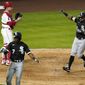 Chicago White Sox&#39;s Adam Eaton, right, scores after hitting a two-run home run as shortstop Tim Anderson, second from right, is congratulated by Jose Abreu, left, and Los Angeles Angels catcher Max Stassi watches during the fifth inning of an Opening Day baseball game Thursday, April 1, 2021, in Anaheim, Calif. (AP Photo/Mark J. Terrill)