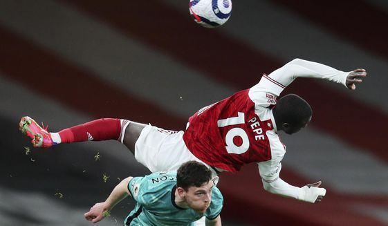 Arsenal&#39;s Nicolas Pepe, right, falls over Liverpool&#39;s Andrew Robertson during the English Premier League soccer match between Arsenal and Liverpool at the Emirates Stadium in London, England, Saturday, April 3, 2021. (Catherine Ivill/Pool via AP)