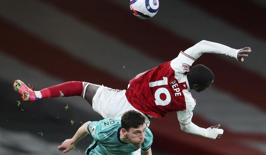 Arsenal&#x27;s Nicolas Pepe, right, falls over Liverpool&#x27;s Andrew Robertson during the English Premier League soccer match between Arsenal and Liverpool at the Emirates Stadium in London, England, Saturday, April 3, 2021. (Catherine Ivill/Pool via AP)