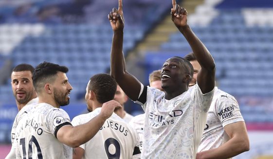 Manchester City&#39;s Benjamin Mendy, right, celebrates after scoring his side&#39;s opening goal during the English Premier League soccer match between Leicester City and Manchester City at the King Power Stadium in Leicester, England, Saturday, April 3, 2021. (AP Photo/Rui Vieira, Pool)