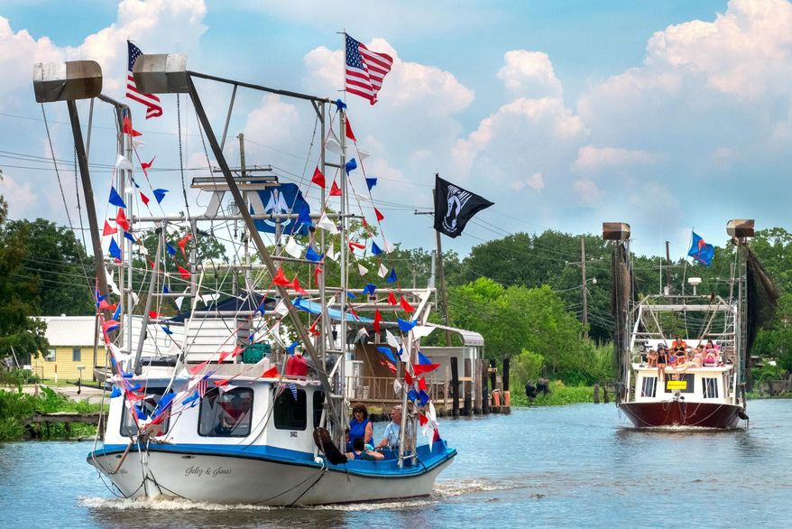 Decorated boats glide down Bayou Little Caillou in Chauvin, La., for the Blessing of the Fleet on April 24, 2016. (Chris Heller/The Courier via AP)