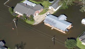 FILE - In this Oct. 10, 2020 file photo, houses surrounded by flood waters are seen in the aftermath of Hurricane Delta Saturday  in Welsh, La.  Hurricane Delta, which made landfall about 11 miles from where the devastating Hurricane Laura hit a little more than a month earlier, cost $2.9 billion in the United States and was linked to six deaths in the U.S. and Mexico, according to a report from the National Hurricane Center. (Bill Feig/The Advocate via AP, Pool, File)