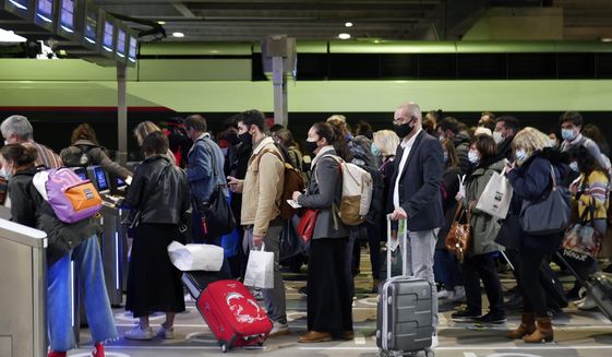 Travelers wait to board a train at the Montparnasse railway station, in Paris, Friday, April 2, 2021. With France now Europe&#39;s latest virus danger zone, Macron on Wednesday ordered temporary school closures nationwide and new travel restrictions. But he resisted calls for a strict lockdown, instead sticking to his &amp;quot;third way&amp;quot; strategy that seeks a route between freedom and confinement to keep both infections and a restless populace under control until mass vaccinations take over. (AP Photo/Thibault Camus)