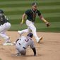 Oakland Athletics shortstop Elvis Andrus, left, cannot field a throwing error by third baseman Matt Chapman, top, as Houston Astros&#x27; Myles Straw (3) advances to second base during the sixth inning of a baseball game in Oakland, Calif., Sunday, April 4, 2021. (AP Photo/Jeff Chiu)