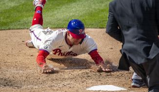 Philadelphia Phillies first baseman Rhys Hoskins (17) slides into home plate to score on an RBI single by Alec Bohm during the eighth inning of a baseball game against the Atlanta Braves, Sunday, April 4, 2021, in Philadelphia. (AP Photo/Laurence Kesterson)