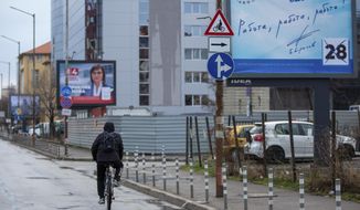 A cyclist passes by election poster of two rival parties in capital Sofia, Bulgaria on Saturday, April 3, 2021. After months of nationwide anti-government protests over corruption, stalled reforms and a stagnating economy in the EU&#39;s poorest member state, Bulgarians are gearing up for a parliamentary election in the shadow of the coronavirus pandemic. (AP Photo/Visar Kryeziu)