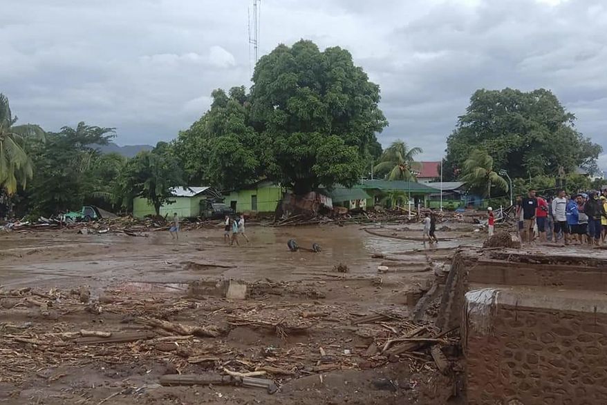 Residents inspect the damage at a village hit by flash flood in East Flores, Indonesia, Sunday, April 4, 2021. Landslides and flash floods from torrential rains in eastern Indonesia have killed a number of people and displaced thousands, the disaster agency said Sunday. (AP Photo/Ola Adonara)