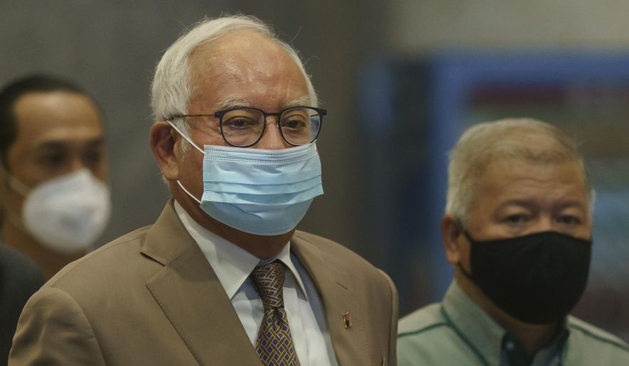 Former Malaysian Prime Minister Najib Razak, center, wearing a face mask arrives at Court of Appeal in Putrajaya, Malaysia, Monday, April 5, 2021. The court Monday began hearing an appeal by Najib  to overturn his conviction and 12-year jail sentence linked to the massive looting of the 1MDB state investment fund that brought down his government in 2018. (AP Photo/Vincent Thian)