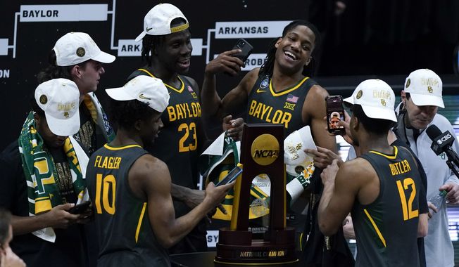 Baylor players celebrate with the trophy at the end of the championship game against Gonzaga in the men&#x27;s Final Four NCAA college basketball tournament, Monday, April 5, 2021, at Lucas Oil Stadium in Indianapolis. Baylor won 86-70. (AP Photo/Michael Conroy)