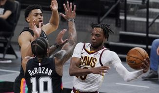 Cleveland Cavaliers guard Darius Garland, right, drives to the basket against San Antonio Spurs forward DeMar DeRozan (10) during the second half of an NBA basketball game in San Antonio, Monday, April 5, 2021. (AP Photo/Eric Gay)