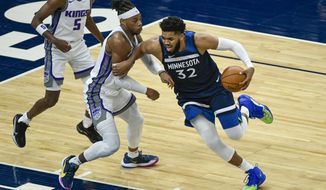 Minnesota Timberwolves center Karl-Anthony Towns (32) is fouled by Sacramento Kings center Richaun Holmes during the first half of an NBA basketball game Monday, April 5, 2021, in Minneapolis. (AP Photo/Craig Lassig)