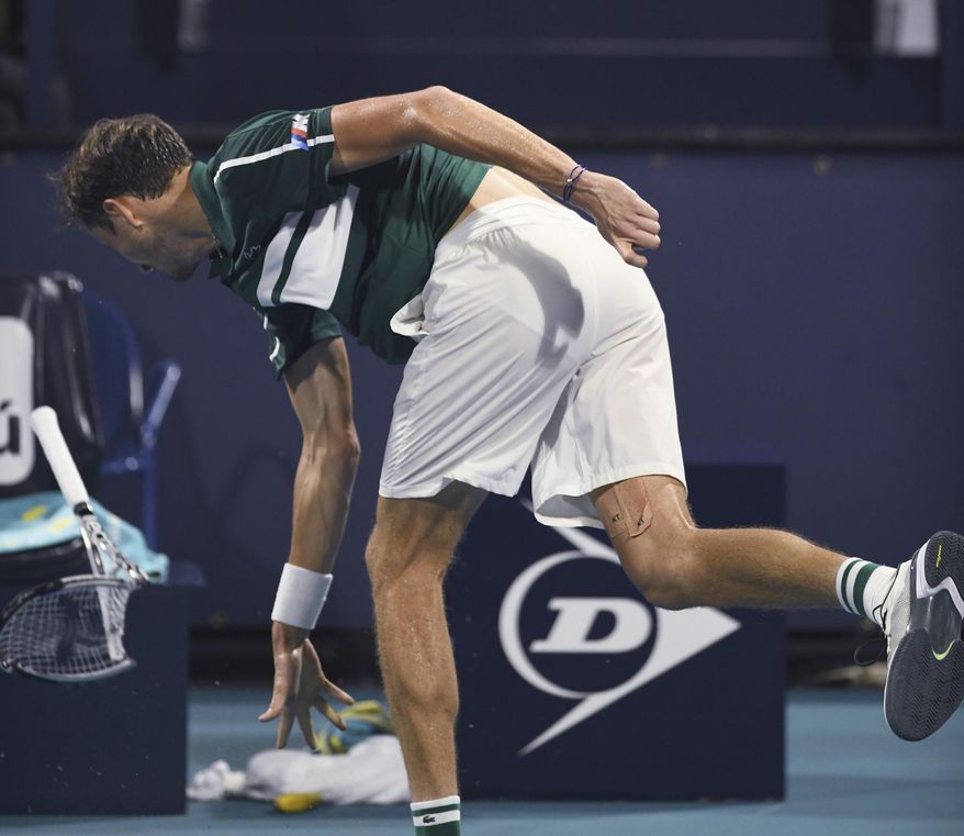 Daniil Medvedev, of Russia throws his already broken racket after losing a game late in the first set to Roberto Bautista Agut, of Spain, during the Miami Open tennis tournament Wednesday March 31, 2021, in Miami Gardens, Fla. Bautista Agut won 6-4, 6-2. (AP Photo/Taimy Alvarez)