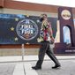 A pedestrian walks past a mock championship trophy before Baylor plays Gonzaga in the NCAA tournament championship basketball game at Lucas Oil Stadium in Indianapolis, Monday, April 5, 2021. (AP Photo/AJ Mast)