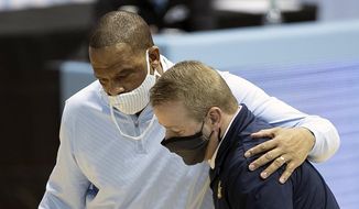 In this Feb. 24, 2021, file photo, North Carolina assistant coach Hubert Davis, left, embraces Marquette coach Steve Wojciechowski following the Marquette&#39;s win in an NCAA college basketball game in Chapel Hill, N.C. North Carolina has reached an agreement with assistant coach Hubert Davis to take over the storied men’s basketball program. (Robert Willett/The News &amp;amp; Observer via AP, File) **FILE**