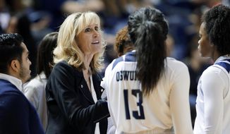 FILE - In this Nov. 17, 2019, file photo, Rice head coach Tina Langley talks with her players during a timeout in the second half of an NCAA college basketball game against Texas A&amp;amp;M in Houston. Washington hired Langley as its new women’s basketball coach Monday, April 5, 2021, giving one of the top coaches in Conference USA over the past six seasons her first shot at leading a Power Five program. (AP Photo/Michael Wyke, File)