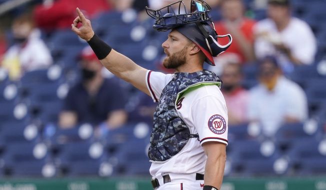 Washington Nationals catcher Jonathan Lucroy gestures in the seventh inning of an opening day baseball game against the Atlanta Braves at Nationals Park, Tuesday, April 6, 2021, in Washington. (AP Photo/Alex Brandon)