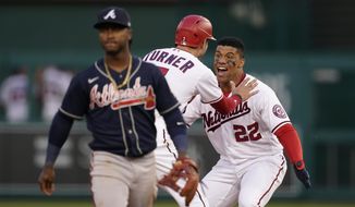 Washington Nationals&#39; Juan Soto (22) and Trea Turner celebrate in front of Atlanta Braves second baseman Ozzie Albies after Soto hit a game-winning single in the ninth inning of an opening day baseball game at Nationals Park, Tuesday, April 6, 2021, in Washington. Victor Robles scored on the play, and Washington won 6-5. (AP Photo/Alex Brandon)