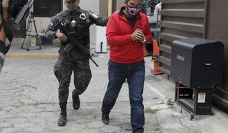 An alleged mastermind of the murder of Honduran environmental and Indigenous rights activist Berta Caceres, Roberto David Castillo is escorted by a police officer upon his arrival to the Supreme Court in Tegucigalpa, Honduras, Tuesday, April 6, 2021. Catillo’s trial began five years after the prize-winning activist&#39;s murder. (AP Photo/Elmer Martinez)