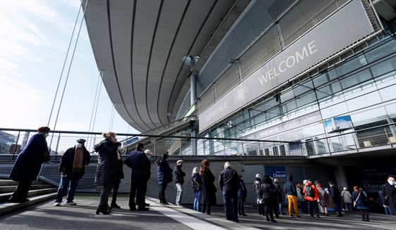 People arrive at the Stade de France stadium to be vaccinated against Covid-19 in Saint-Denis, outside Paris, Tuesday, April 6, 2021. While France remains far behind Britain and the United States in terms of vaccinating its population, the pace is starting to pick up. (Thomas Samson, Pool via AP)