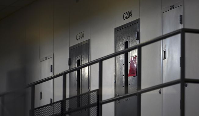 In this Jan. 4, 2021, file photo, a red tag hangs on a cell door, signifying an active COVID-19 case for its inhabitants at Faribault Prison, in Faribault, Minn. Fewer than 20 percent of state and federal prisoners have received a COVID-19 vaccine, according to data collected by The Marshall Project and The Associated Press. In some states, prisoners and advocates have resorted to lawsuits to get access. (Aaron Lavinsky/Star Tribune via AP, File)