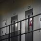 In this Jan. 4, 2021, file photo, a red tag hangs on a cell door, signifying an active COVID-19 case for its inhabitants at Faribault Prison, in Faribault, Minn. Fewer than 20 percent of state and federal prisoners have received a COVID-19 vaccine, according to data collected by The Marshall Project and The Associated Press. In some states, prisoners and advocates have resorted to lawsuits to get access. (Aaron Lavinsky/Star Tribune via AP, File)