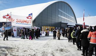 People queue to vote, in the Inussivik arena in Nuuk, Greenland, Tuesday April 6, 2021. Greenland is holding an early parliamentary election Tuesday focused in part on whether the semi-autonomous Danish territory should allow international companies to mine the sparsely populated Arctic island&#39;s substantial deposits of rare-earth metals. (Emil Helms/Ritzau Scanpix via AP)