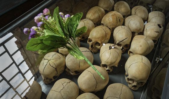 FILE- In this Friday, April 5, 2019 file photo, flowers are laid on top of a glass case containing the skulls of some of those who were slaughtered as they sought refuge in the church, kept as a memorial to the thousands who were killed in and around the Catholic church during the 1994 genocide, inside the church in Ntarama, Rwanda. A commission that spent nearly two years uncovering France&#39;s role in 1994&#39;s Rwandan genocide concluded Friday, March 26, 2021 that the country reacted too slowly in appreciating the extent of the horror that left over 800,000 dead and bears &amp;quot;heavy and overwhelming responsibilities&amp;quot; in the drift that led to the killings, but cleared the country of any complicity in the slaughter that mainly targeted Rwanda&#39;s Tutsi ethnic minority. (AP Photo/Ben Curtis, File)