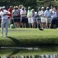 Patrons watches as Bryson DeChambeau skip his ball across the pond to the 16th green during a practice round for the Masters golf tournament at Augusta National Golf Club on Wednesday, April 7, 2021, in Augusta, Ga. (Curtis Compton/Atlanta Journal-Constitution via AP)