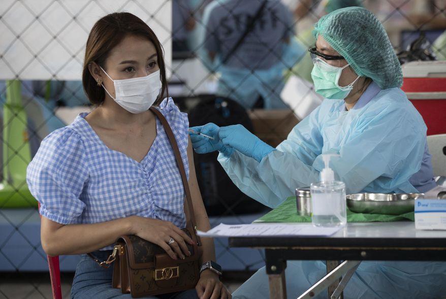 A health worker administers a dose of the Sinovac COVID-19 vaccine to a person working at an entertainment venue where a new cluster of COVID-19 infections was found, in Bangkok, Thailand, Wednesday, April 7, 2021. (AP Photo/Sakchai Lalit)